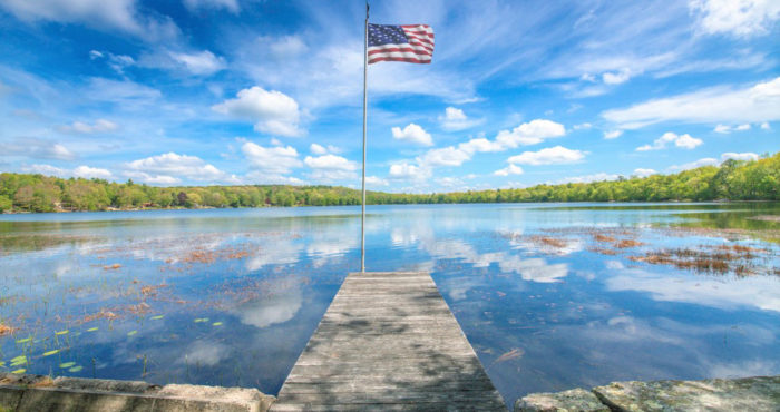 lake with blues skies and an american flag